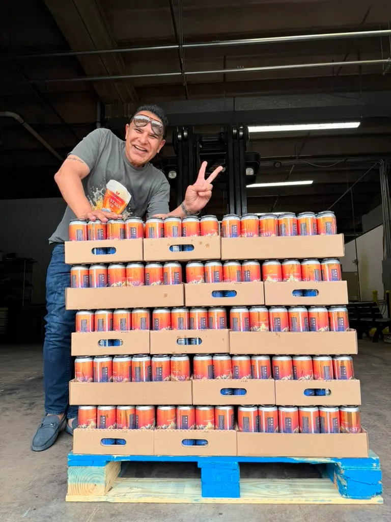 A founder beside a pallet of Mt. Everest and Himalayan cases